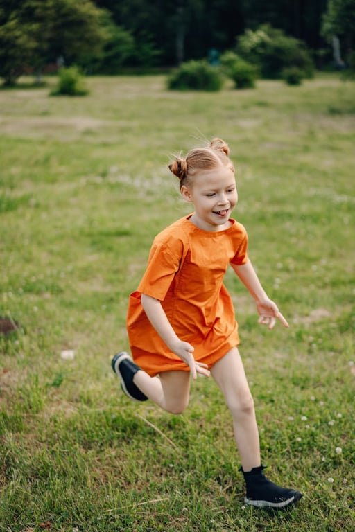 Une jeune fille en robe orange courant dans le parc